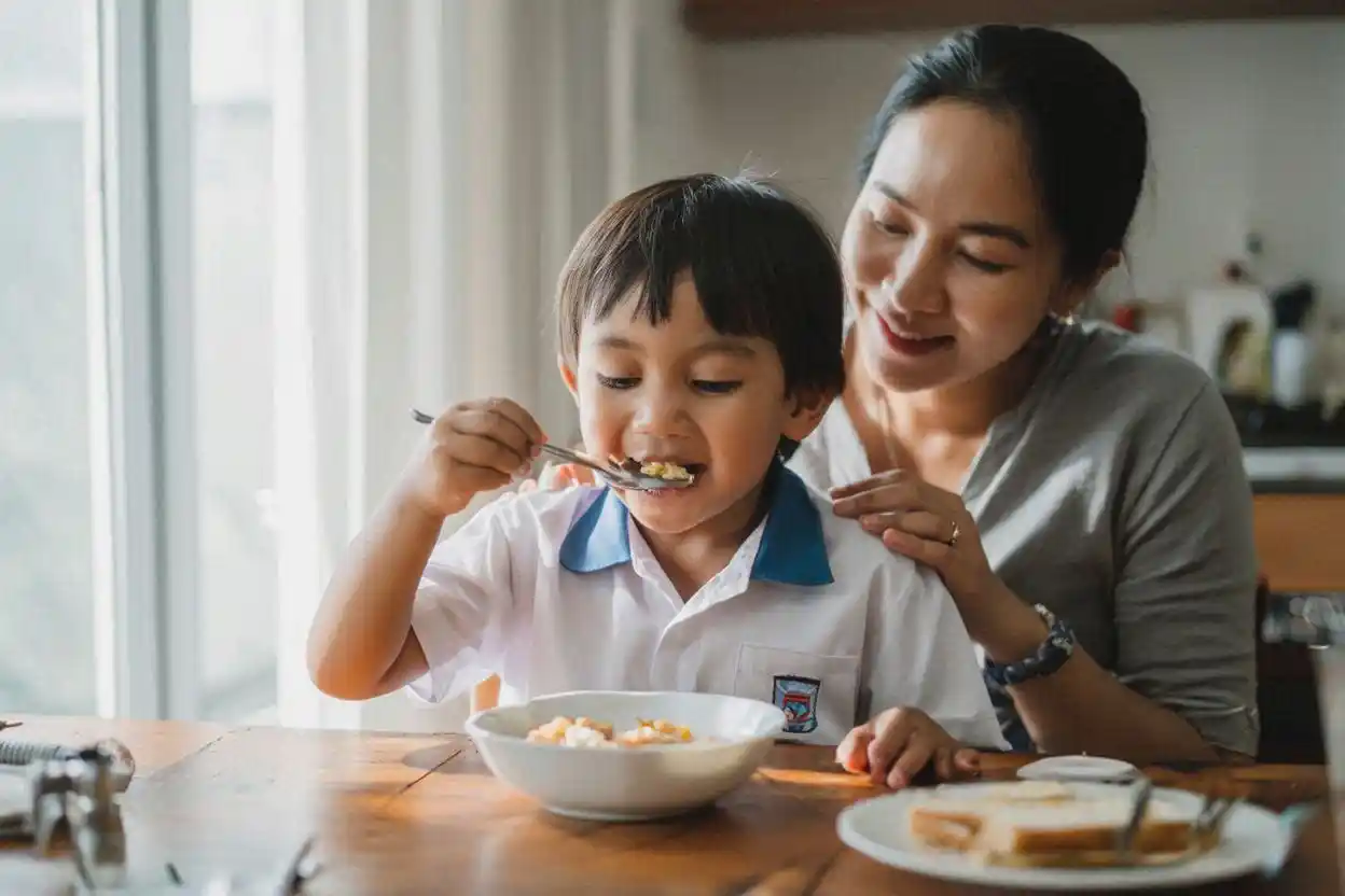 anak TK memulai rutinitas setiap hari dengan sarapan bersama ibu di rumah pada pagi hari